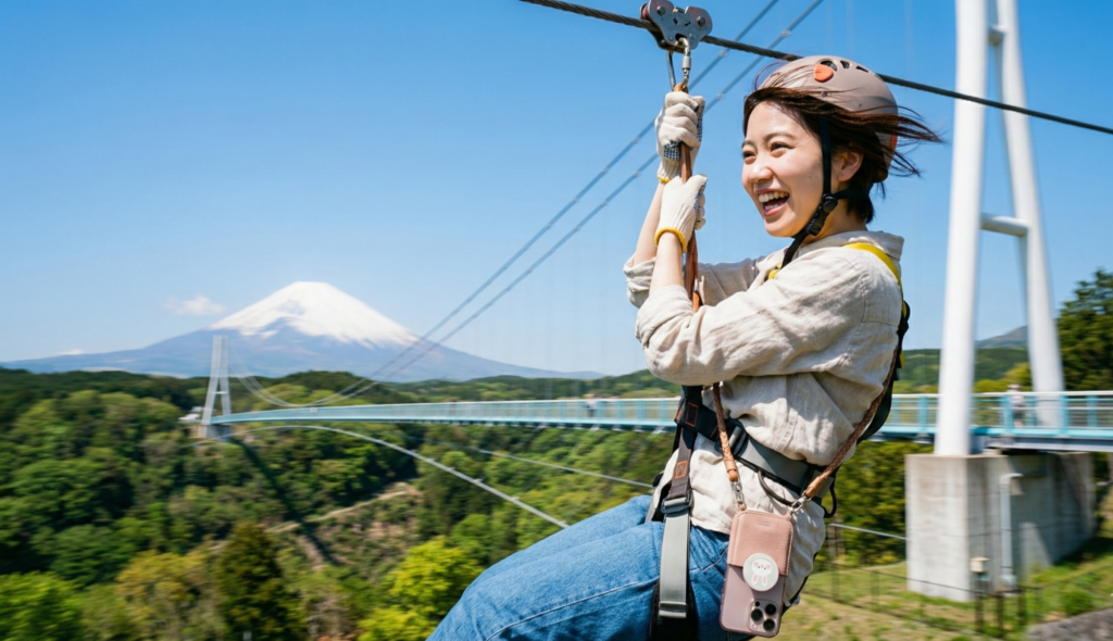 三島スカイウォークのロングジップスライドを滑る女性